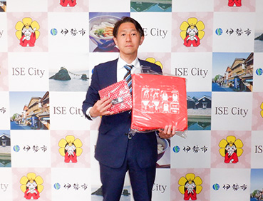 寄贈された浮くっしょんを持つ男性。