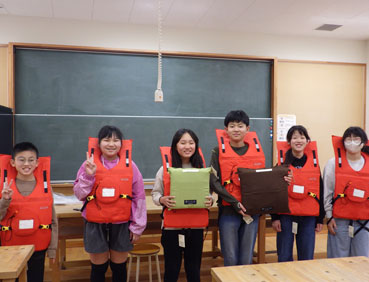 高知県田野町の子供たちが教室で浮くっしょん装着している写真。