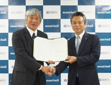 順正学園吉備国際大学とモンベルとの包括連携協定締結式の写真。左にモンベル代表・辰野 勇、右に順正学園吉備国際大学 総長加計勇樹氏が立っています