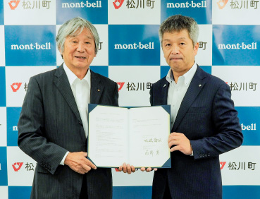 長野県松川町とモンベルとの包括連携協定締結式の写真。左にモンベル代表・辰野 勇、右に松川町・北沢 秀公町長が立っています