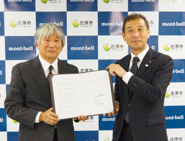 広島県庄原市とモンベルとの包括連携協定締結式の写真。左にモンベル代表・辰野 勇、右に庄原市長 八谷恭介が立っています