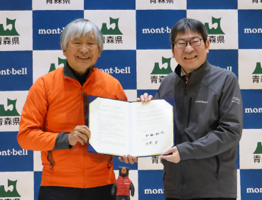青森県と株式会社モンベル代表辰野勇の締結式の様子。左にモンベル代表・辰野勇、青森県副知事・小谷知也氏が写っています。