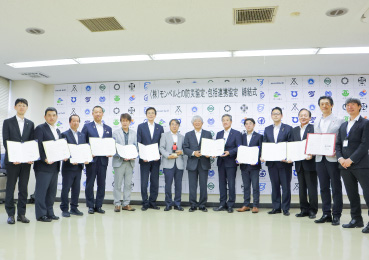 伊豆半島広域防災協議会との協定締結式で並ぶ、モンベル代表・辰野勇氏と関係者