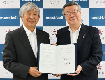 桜井市と株式会社モンベルの締結式の様子。左にモンベル代表・辰野勇、右に桜井市・松井正剛 市長が写っています。