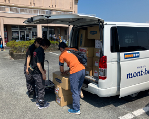 車から支援物資を降ろして渡す様子
