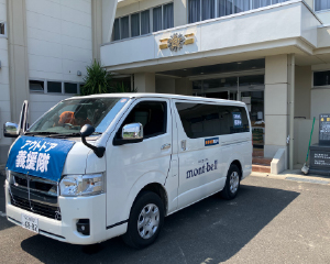 中学校の玄関前に支援物資を載せた車が停まっています。