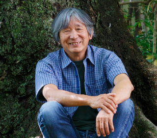 モンベル代表辰野勇が木の前でしゃがんでいるプロフィール画像